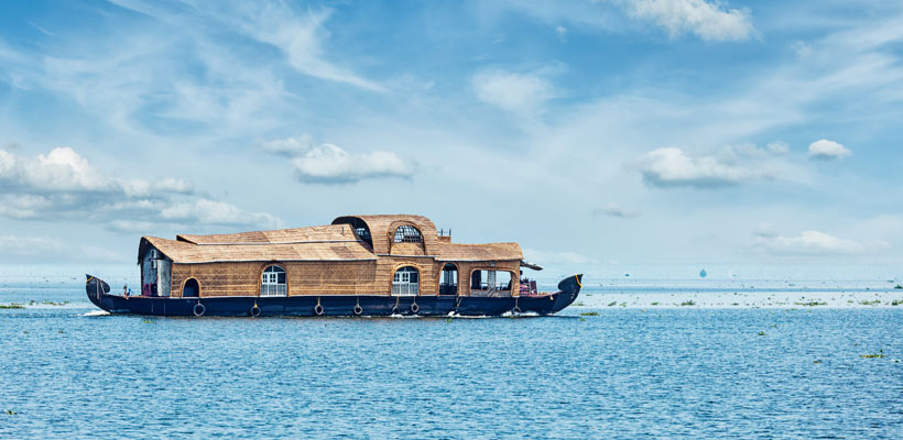 A beautiful view of a houseboat sailing through the Vembanadu Lake at Kumarakom in the state of Kerala, India
